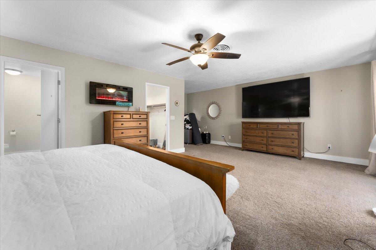 1968 Bechelli Lane Redding, CA 96002 - Photo 14 of 32 a bedroom with a bed and a flat screen tv