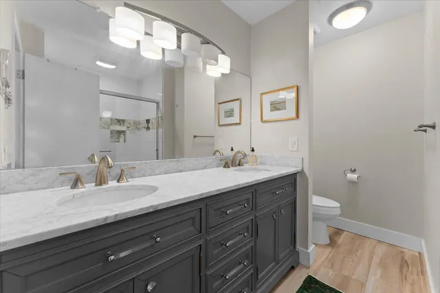 a bathroom with a granite countertop sink a toilet and a mirror
