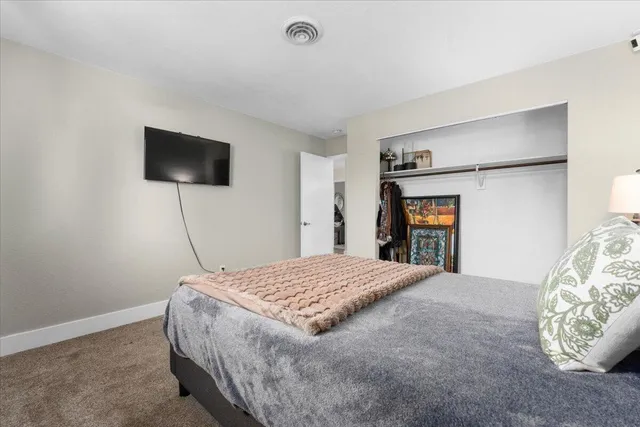 a bedroom with a bed and a flat screen tv