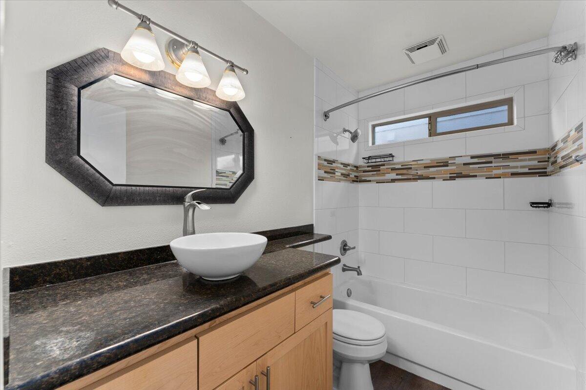 1968 Bechelli Lane Redding, CA 96002 - Photo 20 of 32 a bathroom with a granite countertop sink a toilet and a mirror