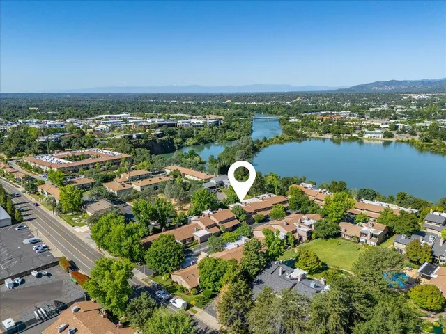 an aerial view of a city with lots of residential buildings ocean and mountain view in back