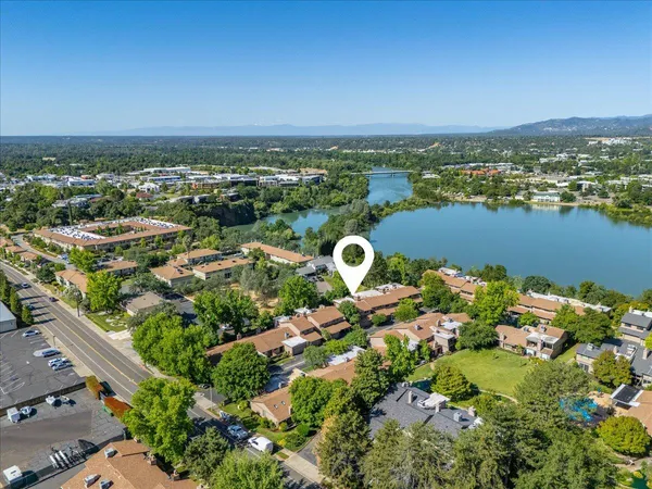 an aerial view of a city with lots of residential buildings ocean and mountain view in back