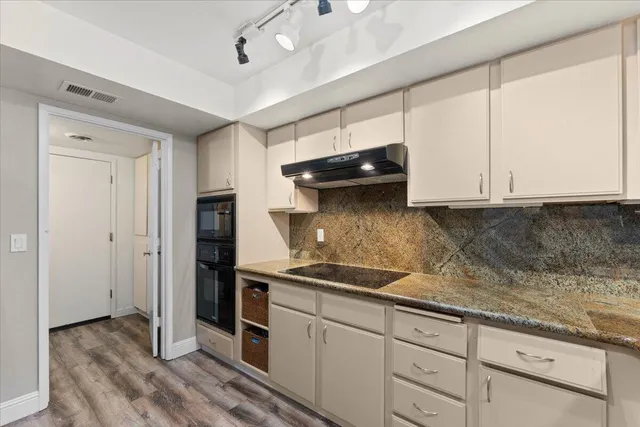 a kitchen with granite countertop a sink and cabinets