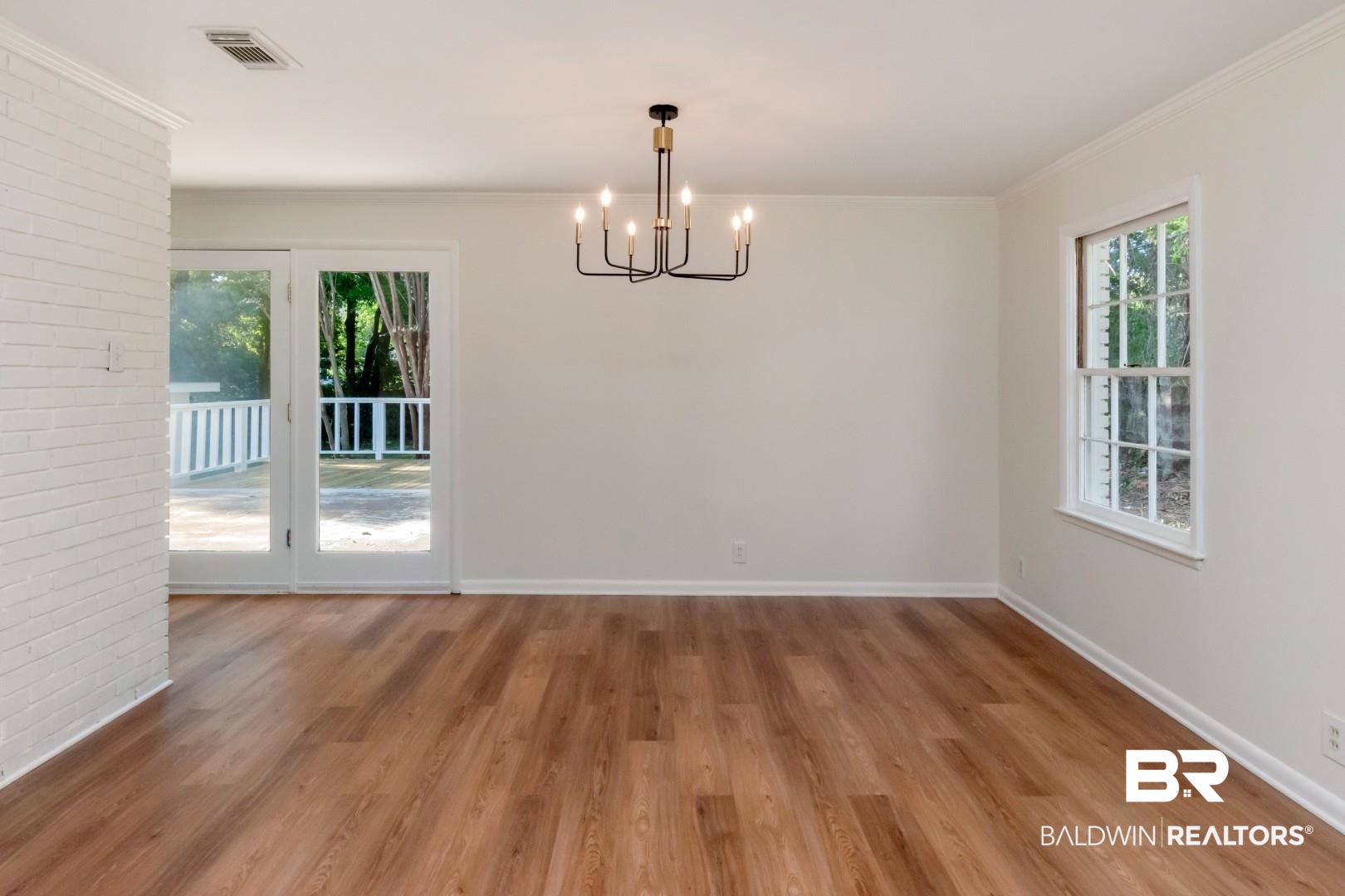 115 Pineridge Road Daphne, AL 36526 - Photo 11 of 34 Unfurnished dining area with wood finished floors, a healthy amount of sunlight, and an inviting chandelier