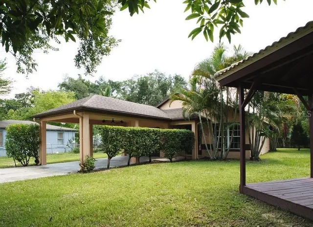 a view of a house with backyard and a backyard