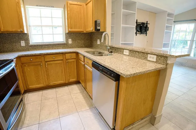 a kitchen with a sink a window and cabinets