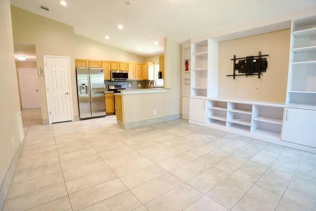 a view of kitchen with refrigerator cabinets and flat screen tv