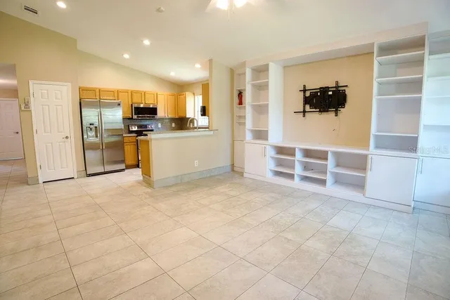 a view of a kitchen with microwave and a refrigerator