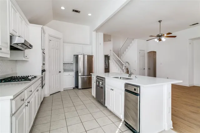a kitchen with white cabinets and appliances