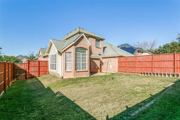 a view of a house with a yard and fence