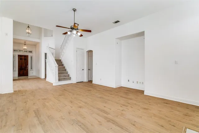 a view of a livingroom with wooden floor and ceiling fan