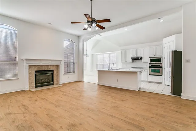 a view of kitchen with cabinets appliances and a ceiling fan