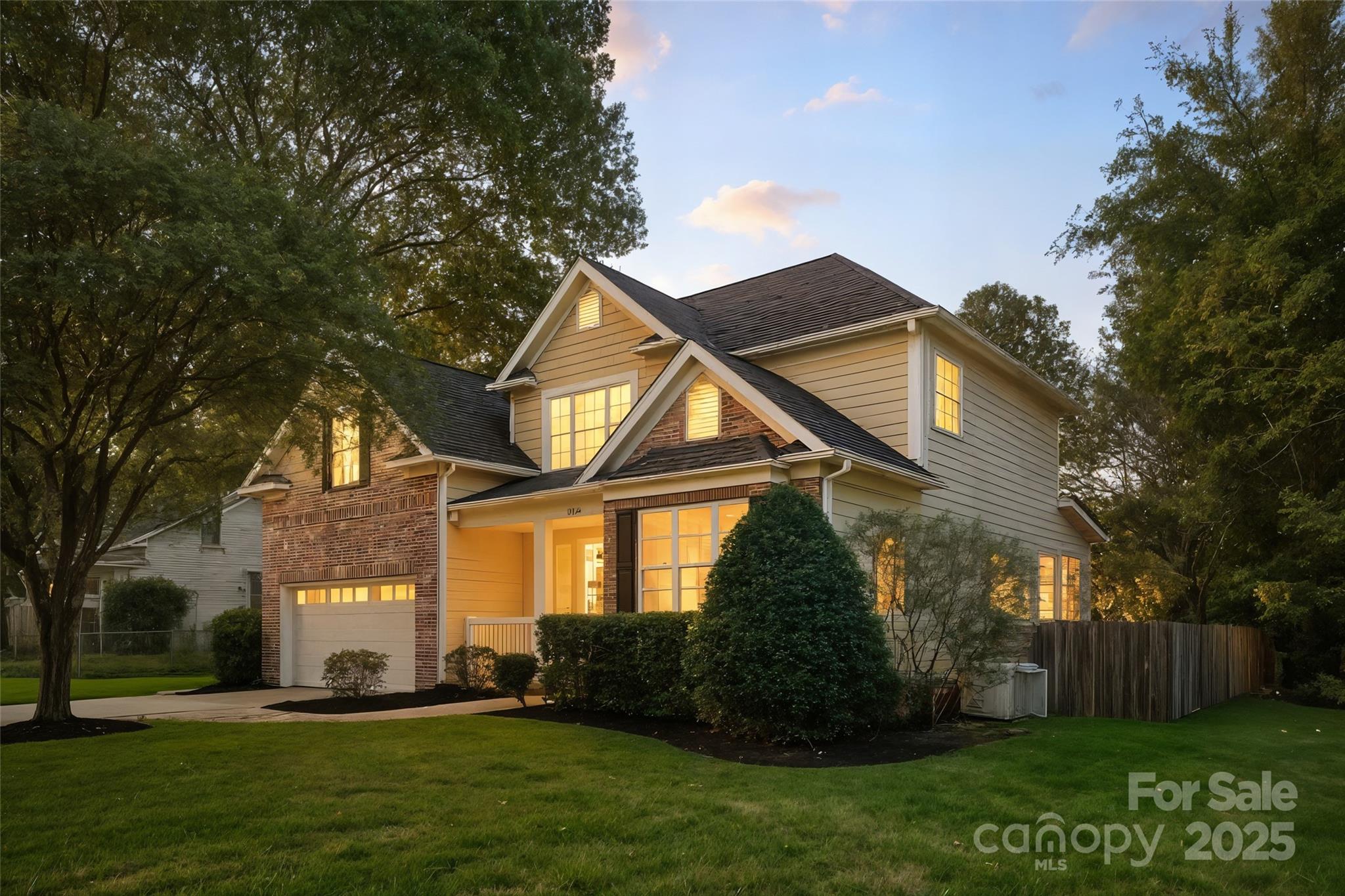 a front view of a house with a yard and potted plants