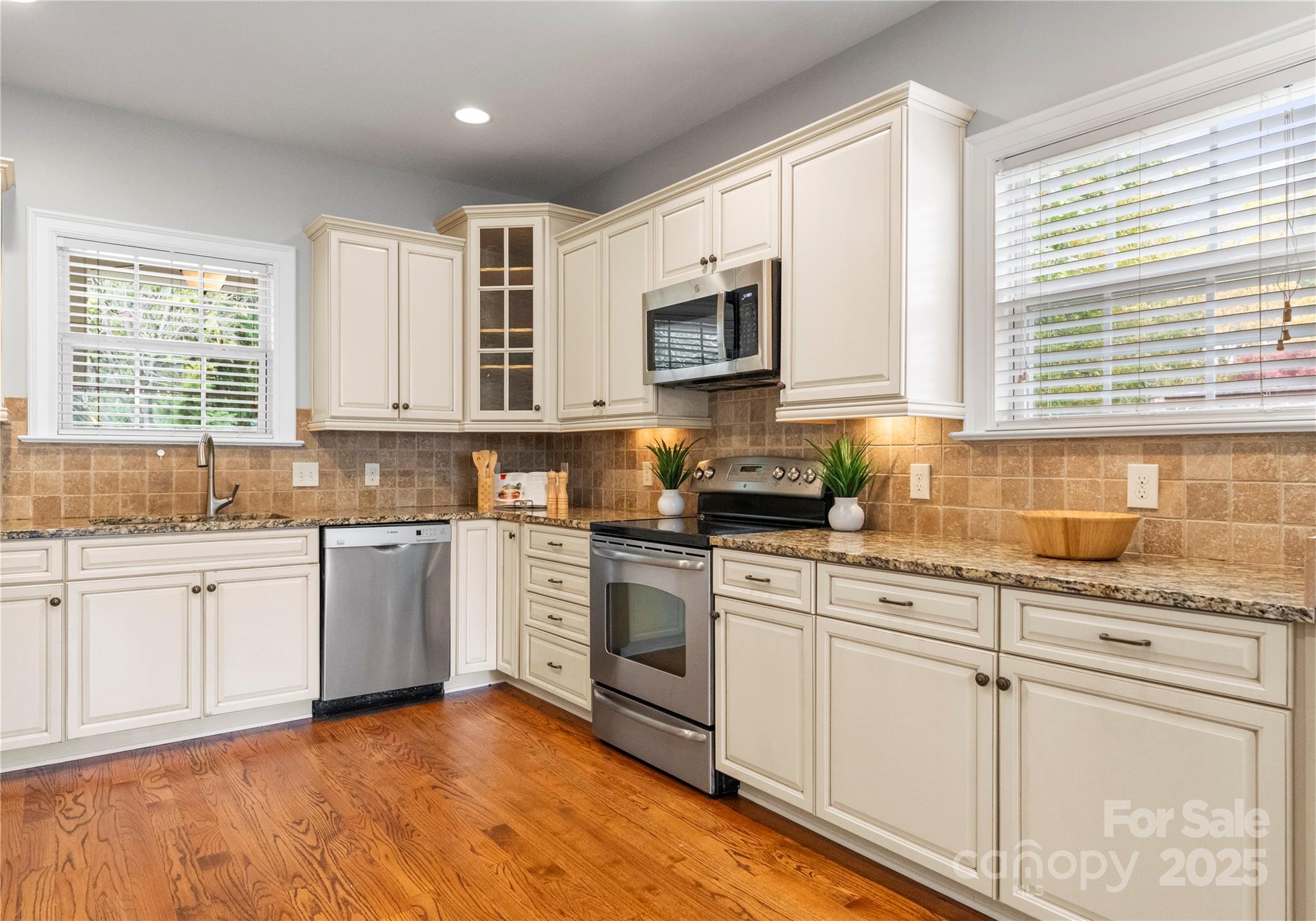 2105 Lanier Avenue Charlotte, NC 28205 - Photo 10 of 31 a kitchen with granite countertop white cabinets a sink a window and stainless steel appliances