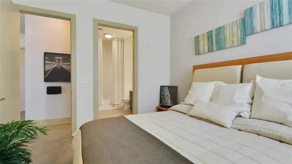 a bedroom with a bed and a potted plant
