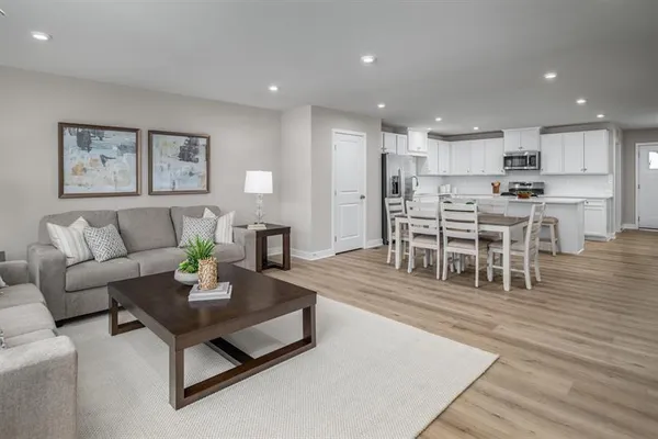 a living room with furniture and a dining table with wooden floor