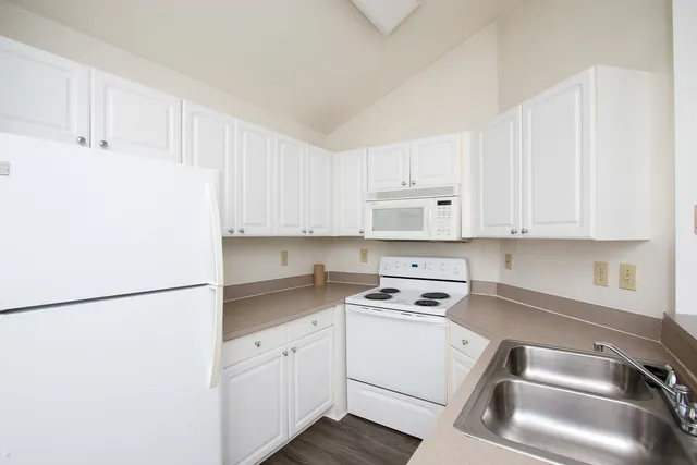 a kitchen with white cabinets and white appliances