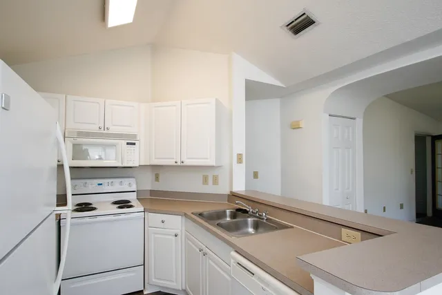 a kitchen with a sink stove and cabinets