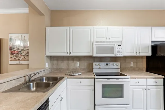 a kitchen with granite countertop white cabinets and sink