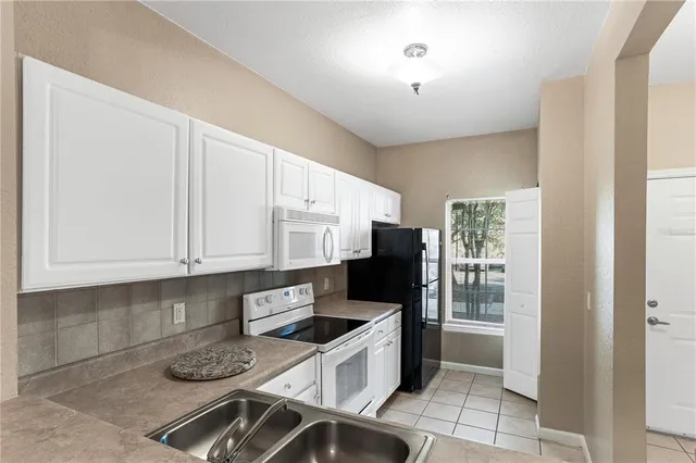 a kitchen with stainless steel appliances granite countertop a stove a refrigerator and cabinets