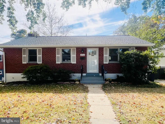 a backyard of a house with a bench and trees