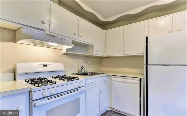 a kitchen with a white stove top oven and refrigerator