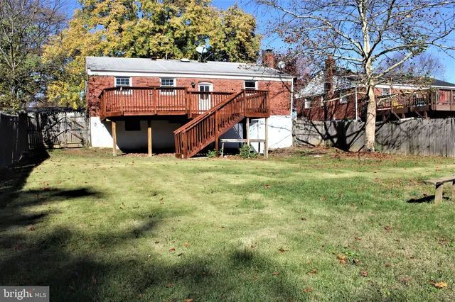 a view of a big house with a big yard and large trees