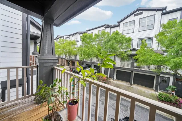 a view of a house with large windows and flower plants