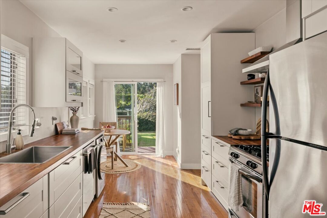 3764 Valleybrink Road Los Angeles, CA 90039 - Photo 13 of 35 a kitchen with stainless steel appliances a sink a counter space and a window