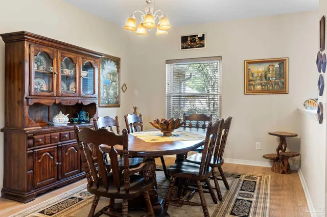 a view of a dining room with furniture a chandelier and wooden floor