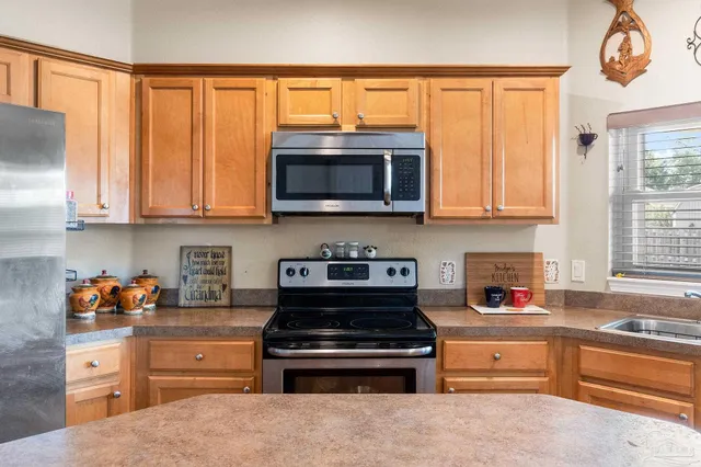 a kitchen with stainless steel appliances granite countertop a stove and a microwave oven on the kitchen countertops