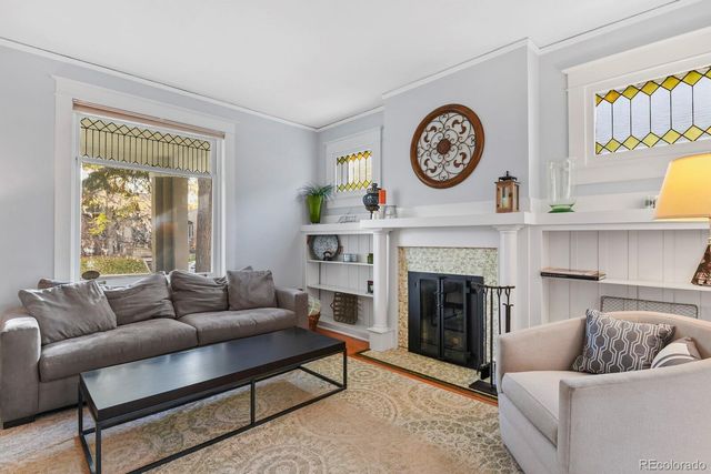 a living room with furniture a clock and a fireplace