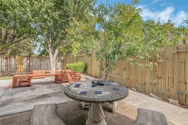 a backyard of a house with barbeque oven table and chairs