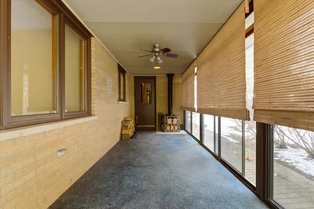 a view of a porch with wooden floor and windows
