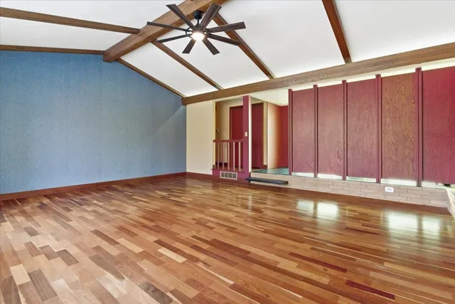 wooden floor fireplace and windows in an empty room
