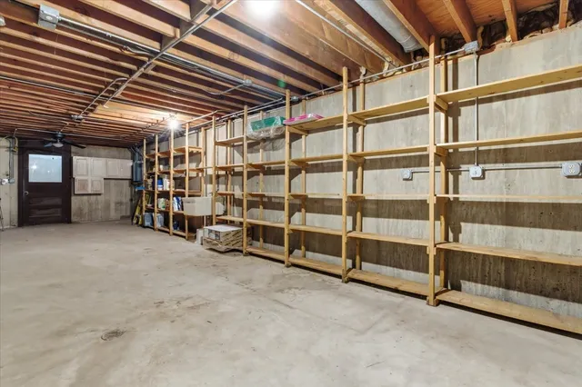 a view of a blue house with snow on the road