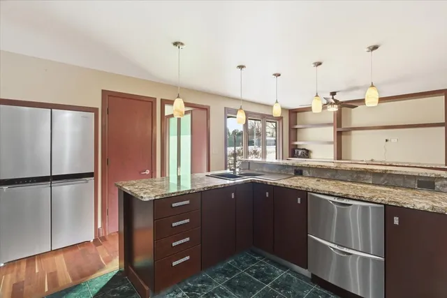 a kitchen with kitchen island granite countertop a sink cabinets and window