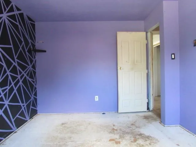 an empty room that has a grey walls