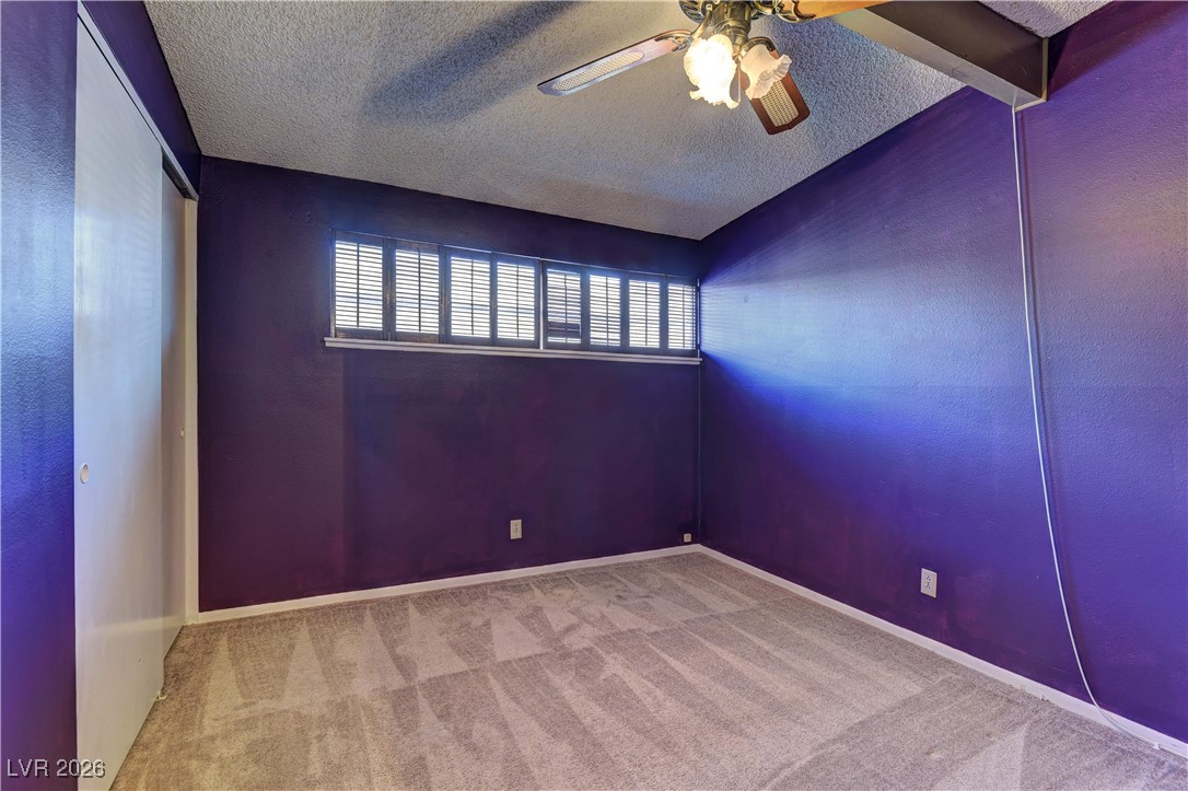 6309 Rassler Avenue Las Vegas, NV 89107 - Photo 13 of 19 Carpeted spare room featuring a textured ceiling and ceiling fan