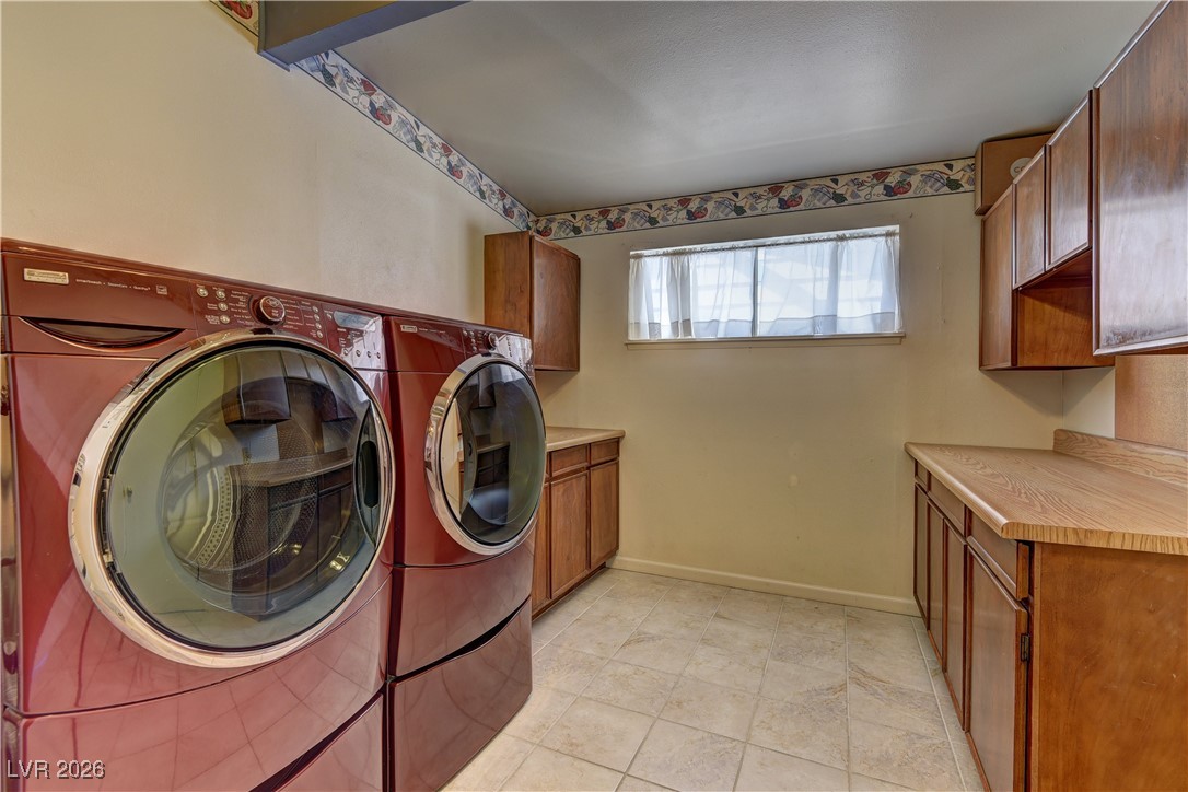 6309 Rassler Avenue Las Vegas, NV 89107 - Photo 15 of 19 Washroom featuring cabinet space, washer and clothes dryer, and light tile patterned floors