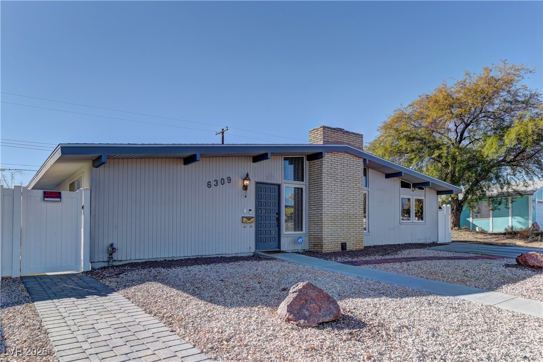 6309 Rassler Avenue Las Vegas, NV 89107 - Photo 2 of 19 Mid-century inspired home with a chimney, a gate, and brick siding