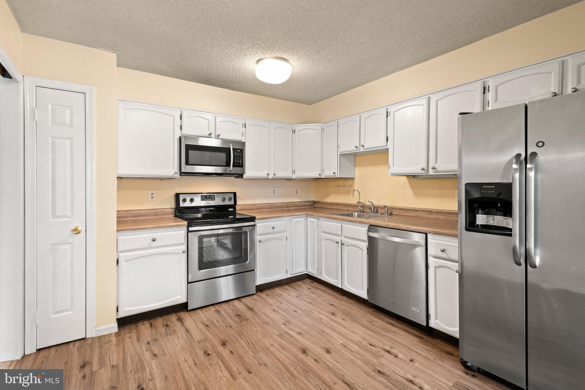 1108 Bartlett Road, Unit 170 Chesterbrook, PA 19087 - Photo 11 of 22 a kitchen with granite countertop a refrigerator stove top oven and sink