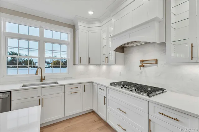 a kitchen with stainless steel appliances kitchen island a large counter top a stove a sink and a refrigerator