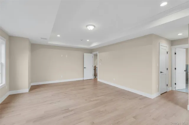 a view of a hallway with wooden floor and windows