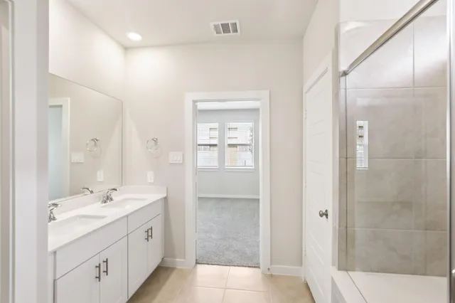 a spacious bathroom with a shower sink and mirror