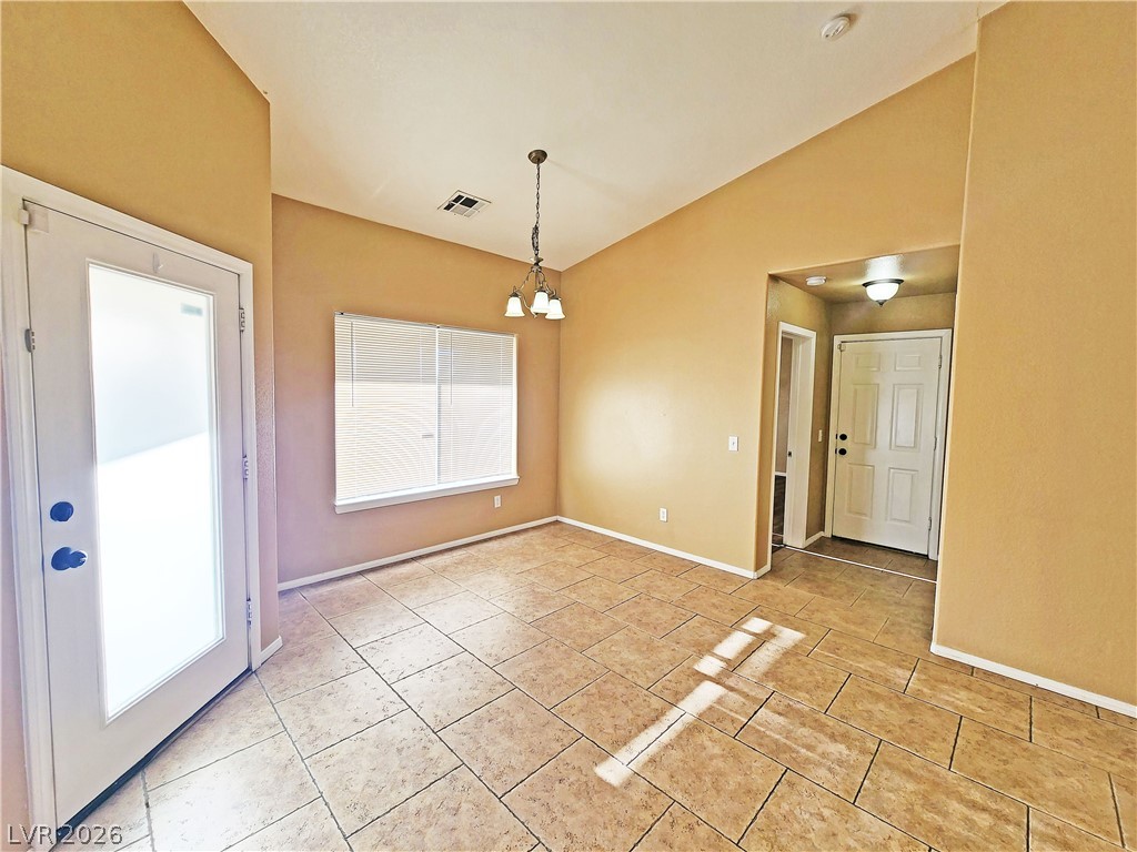 3680 Ravine Avenue Pahrump, NV 89048 - Photo 5 of 28 Empty room featuring lofted ceiling, an inviting chandelier, visible vents, light tile patterned floors, and baseboards