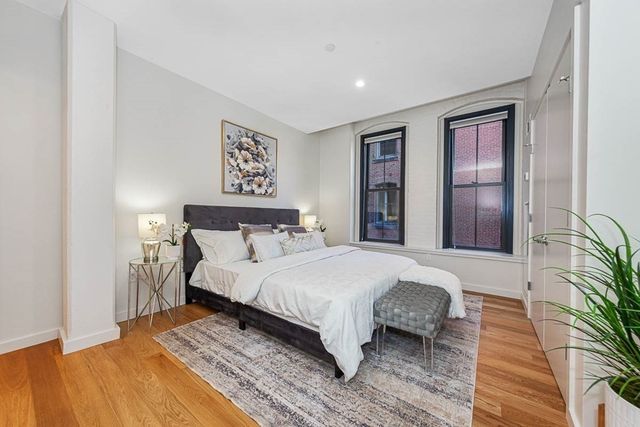 a spacious bedroom with a large bed and a potted plant