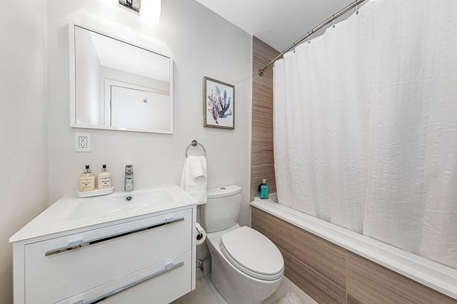 a bathroom with a toilet sink vanity and mirror