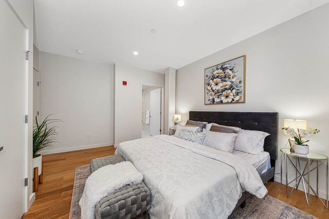 a bedroom with a large bed and a potted plant