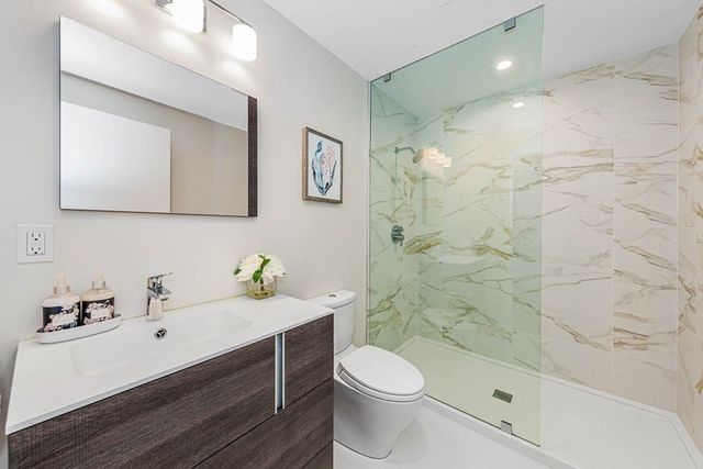 a bathroom with a sink a toilet and shower